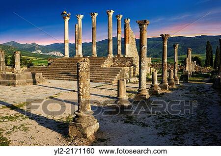 Stock Image - The Corintian columns of Capitoline Temple dedicated to the three chief divinities of the Roman state, Jupiter, Juno and Minerva. Volubilis Archaeological Site, near Meknes, Morocco.. Fotosearch