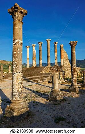 The Corintian columns of Capitoline Temple dedicated to the three chief divinities of the Roman state, Jupiter, Juno and Minerva. Volubilis Archaeological Site, near Meknes, Morocco. View Large Photo Image Stock Photo - The Corintian columns of Capitoline Temple dedicated to the three chief divinities of the Roman state, Jupiter, Juno and Minerva. Volubilis Archaeological Site, near Meknes, Morocco.. Fotosearch
