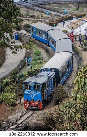 The Darjeeling Himalayan railway crosses the Batasia loop and war memorial in Ghum, West Bengal, India. View Large Photo Image Stock Image - The Darjeeling Himalayan railway crosses the Batasia loop and war memorial in Ghum, West Bengal, India.. Fotosearch