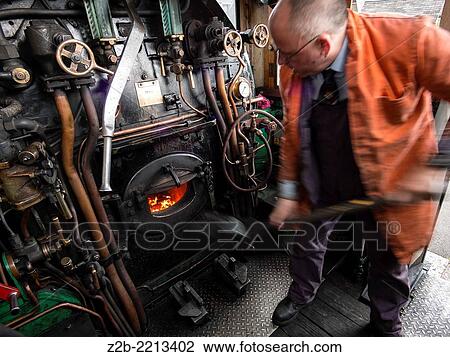 Stock Image - The driver and fireman of a vintage steam engine locomotive, North Yorkshire Moors Railway, on the North Yorkshire Moors, Yorkshire, UK.. Fotosearch