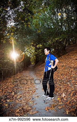 The early morning sun peaks through the trees as a male Korean hiker takes a break in a tree covered area of the Peak Trail at Mission Peak Regional Preserve in Fremont, California View Large Photo Image Stock Photograph - The early morning sun peaks through the trees as a male Korean hiker takes a break in a tree covered area of the Peak Trail at Mission Peak Regional Preserve in Fremont, California. Fotosearch
