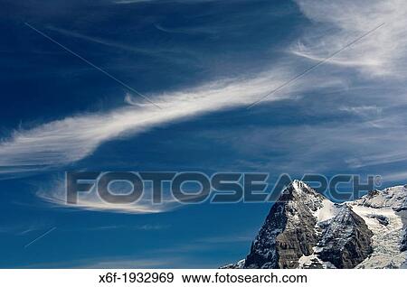The Eiger summit under a dramatic sky with cirrus clouds, Bernese Oberland, Switzerland View Large Photo Image Stock Photo - The Eiger summit under a dramatic sky with cirrus clouds, Bernese Oberland, Switzerland. Fotosearch
