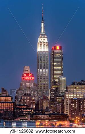 Stock Image - The Empire State Building and Manhattan skyline at dusk, as seen from Weehawken, New Jersey, USA. Fotosearch