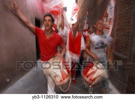 Stock Image - The Giraffe Contrada celebrate winning the Palio with a street procession through the streets, Siena, Italy. Fotosearch