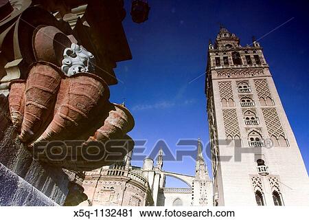 The Giralda Tower reflected on the fountain of Virgen de los Reyes square, Seville, Spain View Large Photo Image Stock Image - The Giralda Tower reflected on the fountain of Virgen de los Reyes square, Seville, Spain. Fotosearch
