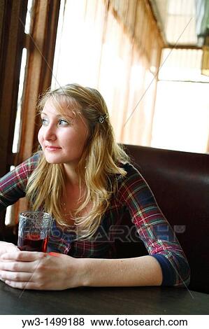 Stock Photo - The girl in cafe drinks cherry juice. Fotosearch
