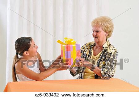 The girl passes the present to the grandma View Large Photo Image Stock Image - The girl passes the present to the grandma. Fotosearch
