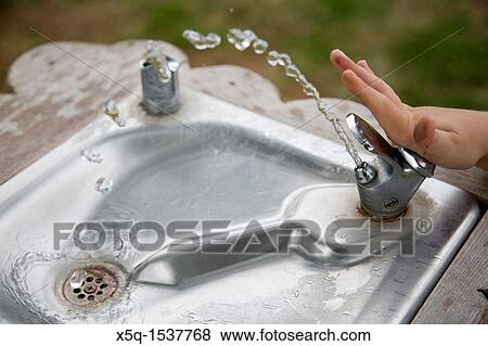 The hand of a child pushing the button of a water fountain View Large Photo Image Stock Photo - The hand of a child pushing the button of a water fountain. Fotosearch