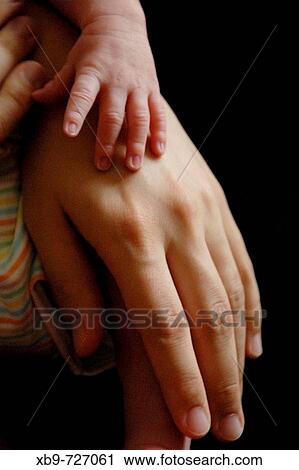 Stock Image - The hands of a baby and a mother. Fotosearch