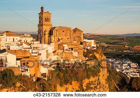 The historic district of the White Town of Arcos de la Frontera dramatically perches on a limestone crack high above the Guadalete river. Prominent the San Pedro church. CBdiz province, Andalusia, Spain. View Large Photo Image Stock Photo - The historic district of the White Town of Arcos de la Frontera dramatically perches on a limestone crack high above the Guadalete river. Prominent the San Pedro church. CBdiz province, Andalusia, Spain.. Fotosearch