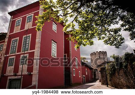 Stock Photo - The House of Culture, in the old town of Llanes. In the background, the tower of the wall. Llanes, Asturias, Spain.. Fotosearch
