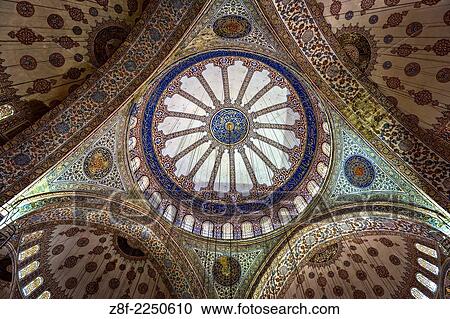 Stock Image - The interior of the Blue Mosque is lined with more than 20, 000 handmade ceramic tiles, made at Iznik city (Nicaea) in more than fifty different tulip designs.. Fotosearch