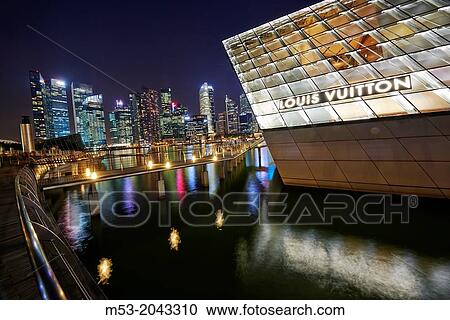 The Loius Vuitton Island Maison, a luxury shop designed by architect Peter Marino located in Marina Bay. In the background the skyscrapes of the Central Business district. Singapore. View Large Photo Image Stock Image - The Loius Vuitton Island Maison, a luxury shop designed by architect Peter Marino located in Marina Bay. In the background the skyscrapes of the Central Business district. Singapore.. Fotosearch