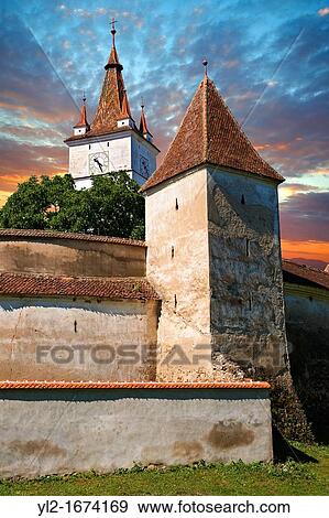 The medieval fortified church of Harman. A Romaneque church started in 1240 by the Cistercian monks with a 14th centurt bell tower & steps leading to storage rooms above the naive. Harman, Brasov, Transylvania. UNESCO World Heritage Site. View Large Photo Image Stock Photo - The medieval fortified church of Harman. A Romaneque church started in 1240 by the Cistercian monks with a 14th centurt bell tower & steps leading to storage rooms above the naive. Harman, Brasov, Transylvania. UNESCO World Heritage Site.. Fotosearch