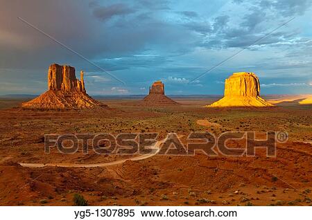 Stock Photography - The Mitten Buttes in the last light during a storm, Monument Valley, Arizona, USA.. Fotosearch