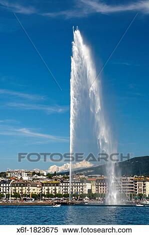 Stock Photography - The monumental water fountain Jet d? Eau at the Lake Geneva lakefront in front of the snowcovered Mont Blanc mountain range in neighbouring France, Geneva, Switzerland. Fotosearch