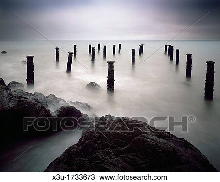 The pillars of the old pier under a grey stormy sky at Westward Ho! on the North Devon coast, England, United Kingdom View Large Photo Image Stock Image - The pillars of the old pier under a grey stormy sky at Westward Ho! on the North Devon coast, England, United Kingdom. Fotosearch