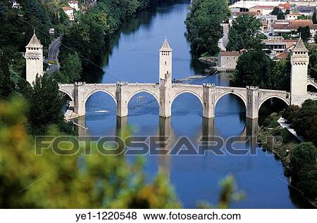The Pont Valentre, a 14th-century fortified stone arch bridge reflected in the Lot River, Cahors, Lot, France. View Large Photo Image Stock Photo - The Pont Valentre, a 14th-century fortified stone arch bridge reflected in the Lot River, Cahors, Lot, France.. Fotosearch