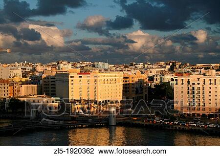 Stock Image - The rising sun casts long shadows as dawn breaks in the Caribbean port city of San Juan, Puerto Rico. Fotosearch