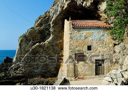 The small Santa Justa Chapel, embedded into the cliff Santa Justa beach, Ubiarco village Santillana del Mar Cantabria Spain View Large Photo Image Stock Photo - The small Santa Justa Chapel, embedded into the cliff Santa Justa beach, Ubiarco village Santillana del Mar Cantabria Spain. Fotosearch