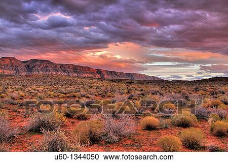 Stock Image - The sun sets on the cliffs bordering Sand hollow in Southern Utah. Fotosearch