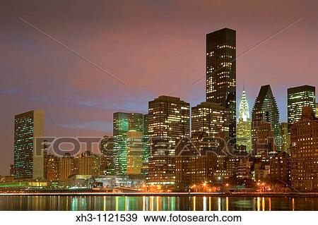 Stock Photo - The U N and the Chrysler Buildings within the NYC skyline from the East River. Fotosearch