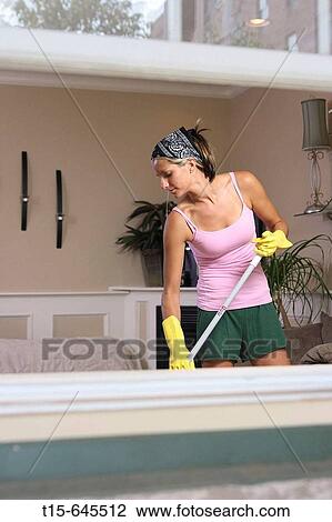 The view from outside of the window of a woman in her 20's sweeping her living room floor View Large Photo Image Stock Image - The view from outside of the window of a woman in her 20's sweeping her living room floor. Fotosearch