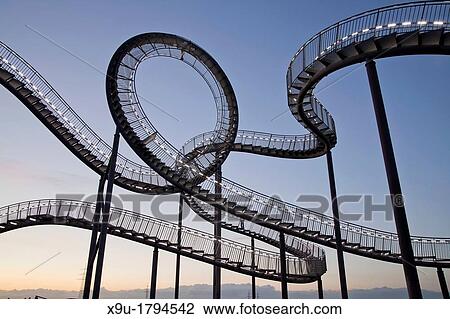Stock Image - The walkable, large outdoor rollercoaster shaped sculpture Tiger & Turtle Magic Mountain, landmark in Duisburg-Angerhausen, Duisburg, North Rhine-Westphalia, Germany, Europe. Fotosearch