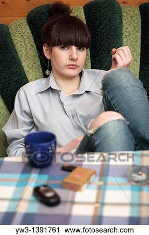 The woman sitting at the table with cap thinking indoors View Large Photo Image Stock Image - The woman sitting at the table with cap thinking indoors. Fotosearch