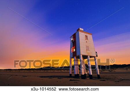 Stock Image - The wooden lighthouse at Burnham-on-Sea at night The cloud in the sky is illuminated from light pollution of nearby sodium street lamps The lighthouse illuminated by both the moon and from the lights from the town of Burnham-on-Sea Somerset, England. Fotosearch