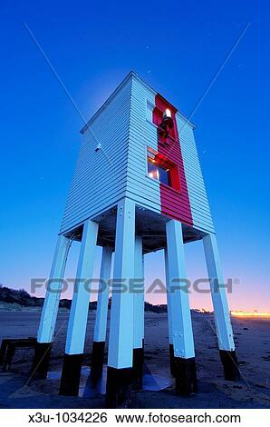 The wooden lighthouse at Burnham-on-Sea at dusk, Somerset, England, United Kingdom The glow of the moon in the sky behind the lighthouse can be seen over the roof Short star trails are visible in the sky View Large Photo Image Stock Photograph - The wooden lighthouse at Burnham-on-Sea at dusk, Somerset, England, United Kingdom The glow of the moon in the sky behind the lighthouse can be seen over the roof Short star trails are visible in the sky. Fotosearch