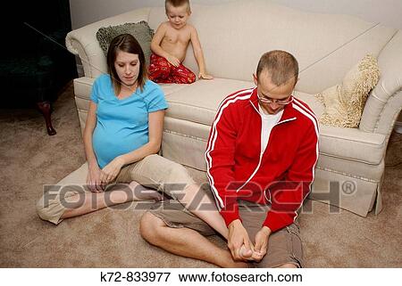 The young son enjoys watching his father rub his pregnant mother's foot View Large Photo Image Stock Photo - The young son enjoys watching his father rub his pregnant mother's foot. Fotosearch