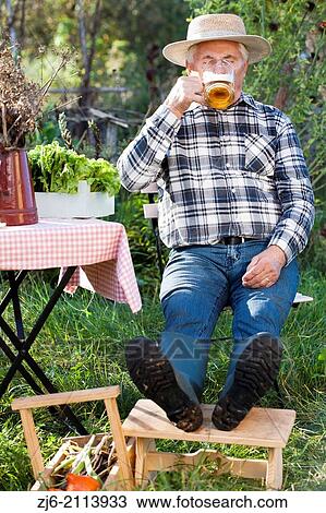 Thirsty man with glass of bear relaxing in the garden. View Large Photo Image Stock Image - Thirsty man with glass of bear relaxing in the garden.. Fotosearch