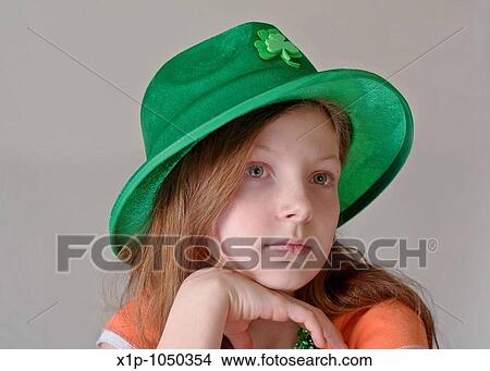 This beautiful green eyed, 9 year old Caucasian girl is wearing a green St Patrick's Day hat in a closeup on a light background Her facial expression is a more serious tone and her chin is resting on her hand View Large Photo Image Picture - This beautiful green eyed, 9 year old Caucasian girl is wearing a green St Patrick's Day hat in a closeup on a light background Her facial expression is a more serious tone and her chin is resting on her hand. Fotosearch