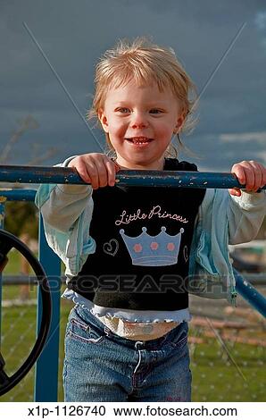 This blond hair, blue eyed toddler two year old girl is outside playing with the wind blowing her hair on a stormy day The skies behind her are dark and dramatic View Large Photo Image Stock Image - This blond hair, blue eyed toddler two year old girl is outside playing with the wind blowing her hair on a stormy day The skies behind her are dark and dramatic. Fotosearch