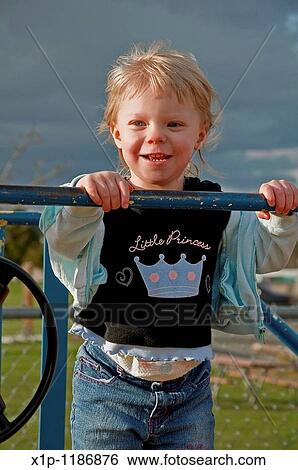 This blond hair, blue eyed toddler two year old girl is outside playing with the wind blowing her hair on a stormy day The skies behind her are dark and dramatic View Large Photo Image Stock Photograph - This blond hair, blue eyed toddler two year old girl is outside playing with the wind blowing her hair on a stormy day The skies behind her are dark and dramatic. Fotosearch
