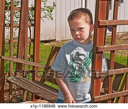This Caucasian 5 year old boy is sad and upset as he's leaning against a cedar swing outside His eyes and facial expression and body language convey deep emotions View Large Photo Image Stock Photo - This Caucasian 5 year old boy is sad and upset as he's leaning against a cedar swing outside His eyes and facial expression and body language convey deep emotions. Fotosearch