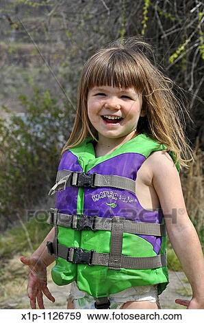This cute 3 year old Caucasian girl is smiling and happy while playing outdoors She's wearing a green life vest and coverd in mud as she's been playing View Large Photo Image Stock Photo - This cute 3 year old Caucasian girl is smiling and happy while playing outdoors She's wearing a green life vest and coverd in mud as she's been playing. Fotosearch