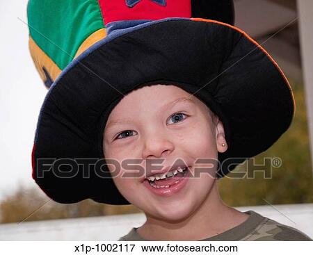 This cute 4 year old Caucasian boy with freckles and an earring is happy and smiling while wearing a colorful wacky hat Background is intentionally blurred for artistic effect View Large Photo Image Stock Photo - This cute 4 year old Caucasian boy with freckles and an earring is happy and smiling while wearing a colorful wacky hat Background is intentionally blurred for artistic effect. Fotosearch