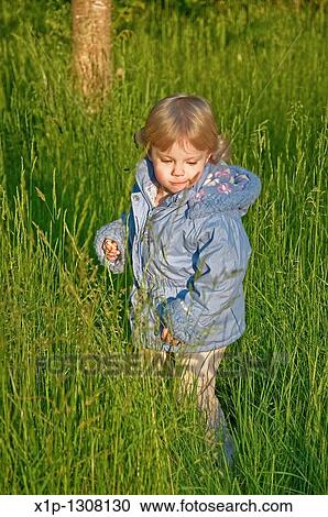This cute blond haired Caucasian toddler 2 year old girl is wearing a blue coat while playing outdoors in the tall grass Vertical stock image, background intentionally blurred to emphasize subject View Large Photo Image Stock Image - This cute blond haired Caucasian toddler 2 year old girl is wearing a blue coat while playing outdoors in the tall grass Vertical stock image, background intentionally blurred to emphasize subject. Fotosearch