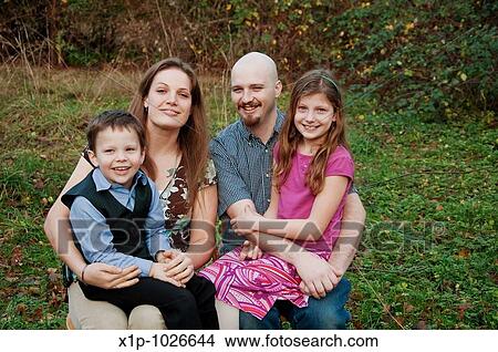 This happy Caucasian family is outdoors together with mother, family, son and daughter Background is intentionally blurred for artistic effect View Large Photo Image Picture - This happy Caucasian family is outdoors together with mother, family, son and daughter Background is intentionally blurred for artistic effect. Fotosearch