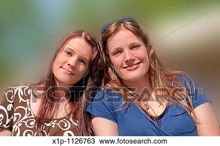 This stock photo are two young adult Caucasian brunette women both with long hair and smiling who are both sisters and friends They are in their early twenties Background intentionally blurred to emphasize subjects View Large Photo Image Stock Image - This stock photo are two young adult Caucasian brunette women both with long hair and smiling who are both sisters and friends They are in their early twenties Background intentionally blurred to emphasize subjects. Fotosearch