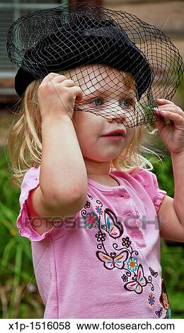 This vertical image shows a cute 2 year old Caucasian girl, wearing a black vintage hat with a veil over her face View Large Photo Image Stock Photo - This vertical image shows a cute 2 year old Caucasian girl, wearing a black vintage hat with a veil over her face. Fotosearch
