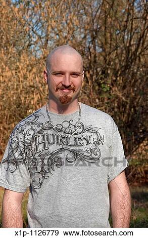 This vertical portrait of a mid-twenties Caucasian man, smiling outdoors in early spring He has light skin and a warm smile, a goatee with his head shaved bald View Large Photo Image Stock Photo - This vertical portrait of a mid-twenties Caucasian man, smiling outdoors in early spring He has light skin and a warm smile, a goatee with his head shaved bald. Fotosearch