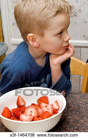 Thoughtful boy age 4 enjoying a bowel of sliced strawberries St Paul Minnesota MN USA View Large Photo Image Stock Photo - Thoughtful boy age 4 enjoying a bowel of sliced strawberries St Paul Minnesota MN USA. Fotosearch