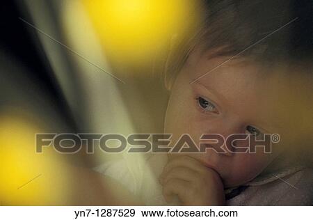 thoughtful young child seen through blurred out flowers View Large Photo Image Stock Photo - thoughtful young child seen through blurred out flowers. Fotosearch