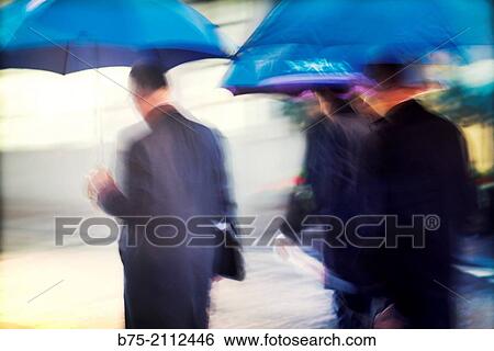 Three blur executive unrecognizable with a blue umbrella on a rainy day in the city of London, England, UK, Europe. View Large Photo Image Stock Photograph - Three blur executive unrecognizable with a blue umbrella on a rainy day in the city of London, England, UK, Europe.. Fotosearch