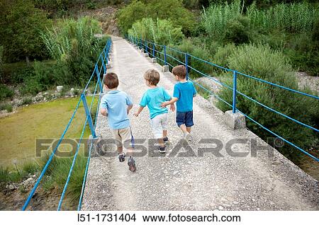 three boys crossing an old bridge on the country, Ludiente, Castell? n, Spain View Large Photo Image Picture - three boys crossing an old bridge on the country, Ludiente, Castell? n, Spain. Fotosearch