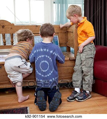 Three boys playing on a computer View Large Photo Image Picture - Three boys playing on a computer. Fotosearch