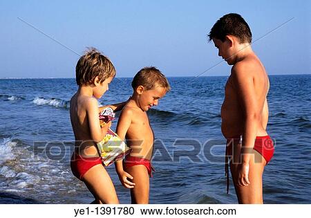Three boys playing together at the beach View Large Photo Image Stock Image - Three boys playing together at the beach. Fotosearch